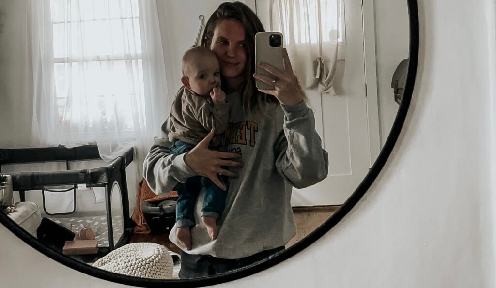 Meghan holding Declan in a mirror picture.